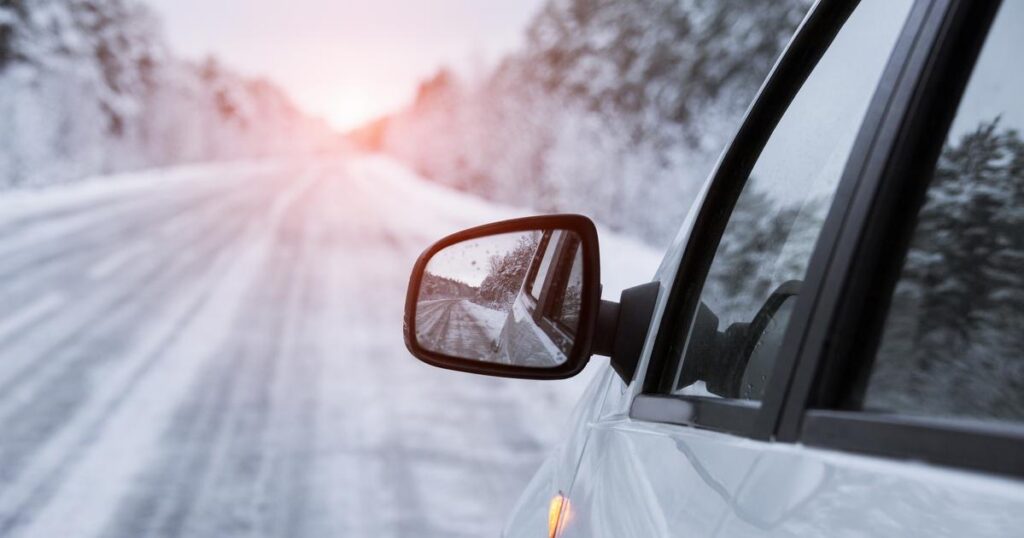 Winter road is reflected in the car's mirror